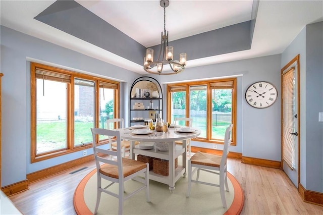 12704 Mohawk Cir, Leawood, KS 66209 - dining area with a tray ceiling, baseboards, a chandelier, and light wood-style flooring