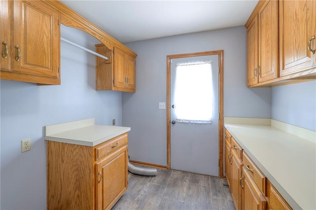 12704 Mohawk Cir, Leawood, KS 66209 - washroom with cabinet space and wood finished floors