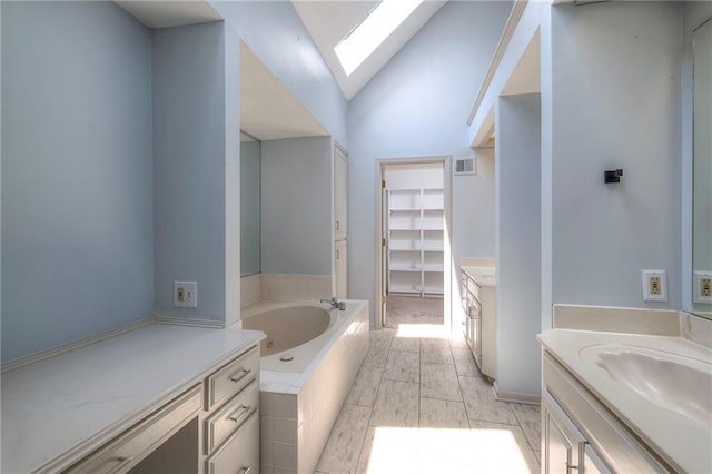12704 Mohawk Cir, Leawood, KS 66209 - bathroom with a skylight, two vanities, a garden tub, lofted ceiling, and a closet