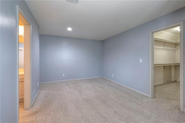 12704 Mohawk Cir, Leawood, KS 66209 - unfurnished bedroom with carpet, a walk in closet, baseboards, recessed lighting, and a closet