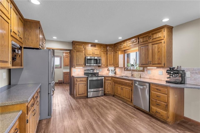205 N 1700th Rd, Lecompton, KS 66050 - kitchen featuring appliances with stainless steel finishes, brown cabinetry, a sink, decorative backsplash, and recessed lighting