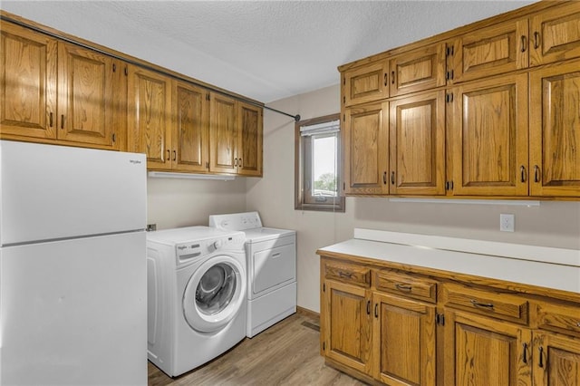 205 N 1700th Rd, Lecompton, KS 66050 - washroom with cabinet space, separate washer and dryer, light wood finished floors, and a textured ceiling