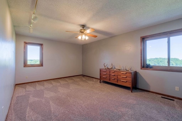 205 N 1700th Rd, Lecompton, KS 66050 - empty room with carpet, track lighting, ceiling fan, baseboards, and a textured ceiling
