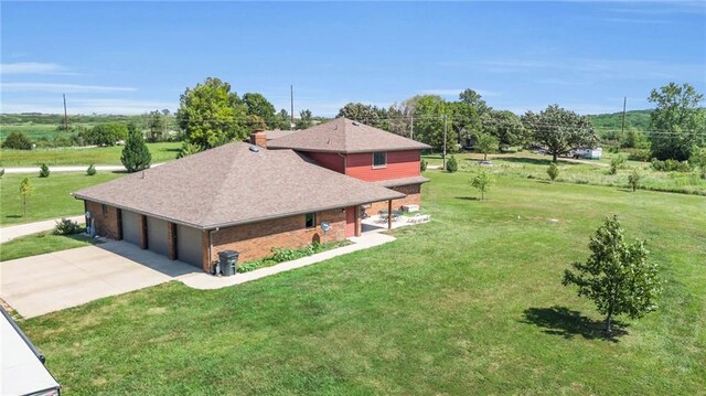 205 N 1700th Rd, Lecompton, KS 66050 - view of property exterior with a yard, a shingled roof, driveway, a garage, and a chimney