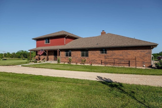 205 N 1700th Rd, Lecompton, KS 66050 - view of home's exterior with a yard, a chimney, brick siding, and covered porch