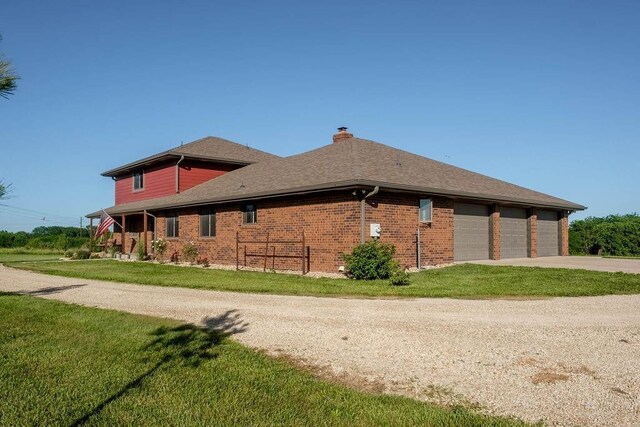 205 N 1700th Rd, Lecompton, KS 66050 - view of side of property featuring concrete driveway, a chimney, a yard, brick siding, and an attached garage