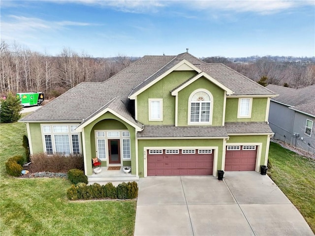 view of front facade featuring a front lawn, a garage, roof with shingles, concrete driveway, and stucco siding