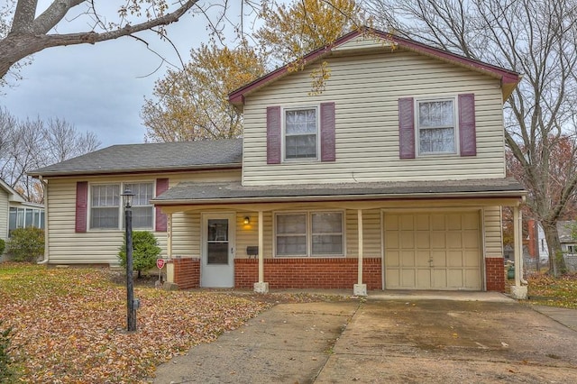 view of front of house featuring concrete driveway, a shingled roof, an attached garage, and brick siding