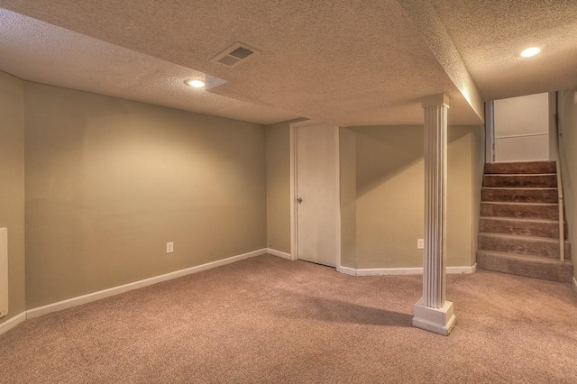 finished below grade area with stairway, a textured ceiling, visible vents, and carpet flooring