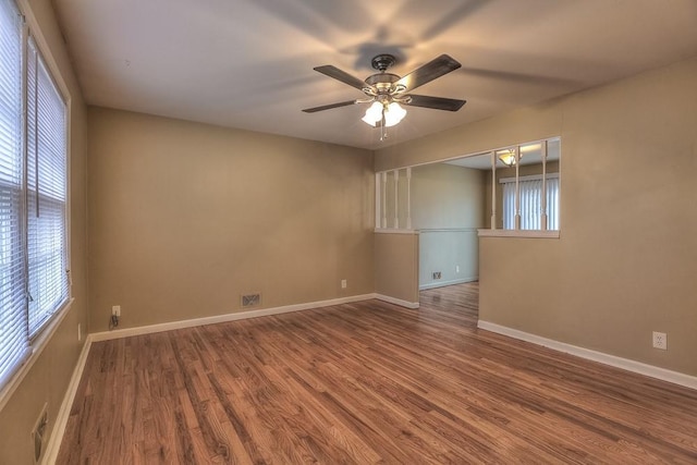 spare room featuring a ceiling fan, wood finished floors, and baseboards
