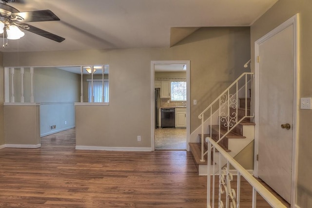 interior space with stairway, wood finished floors, a ceiling fan, and baseboards