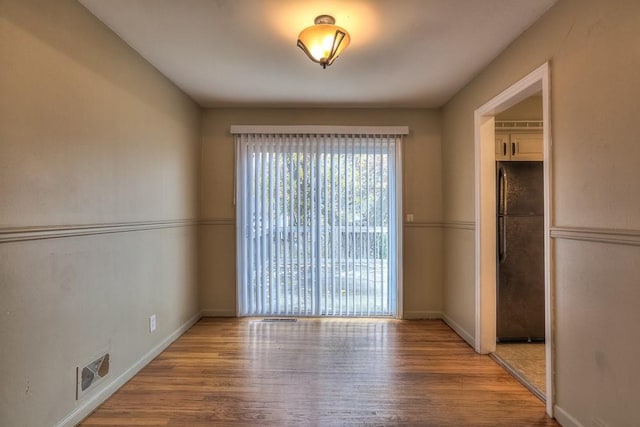 interior space with wood finished floors, visible vents, and baseboards