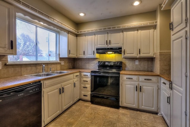 kitchen with black appliances, under cabinet range hood, light countertops, and a sink