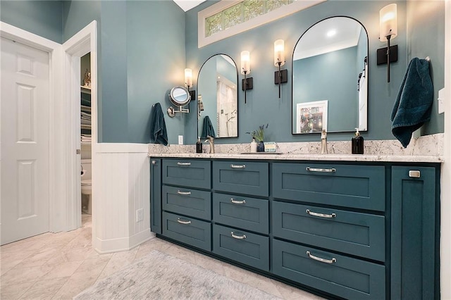 5484 NE Northgate Xing, Lees Summit, MO 64064 - bathroom featuring toilet, double vanity, and a wainscoted wall