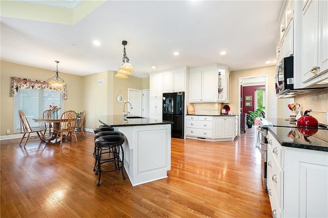 5484 NE Northgate Xing, Lees Summit, MO 64064 - kitchen featuring freestanding refrigerator, a sink, stainless steel microwave, dark countertops, and healthy amount of natural light