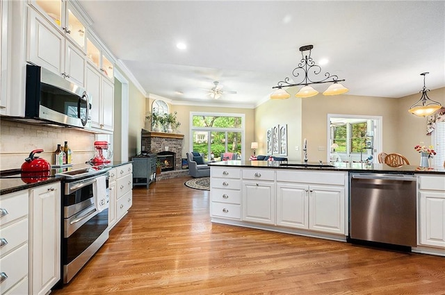 5484 NE Northgate Xing, Lees Summit, MO 64064 - kitchen featuring appliances with stainless steel finishes, a sink, dark countertops, a ceiling fan, and plenty of natural light