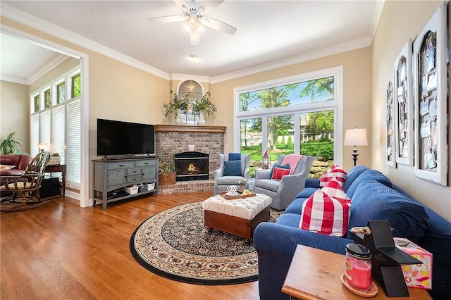 5484 NE Northgate Xing, Lees Summit, MO 64064 - living room with wood finished floors, ornamental molding, a ceiling fan, and a brick fireplace