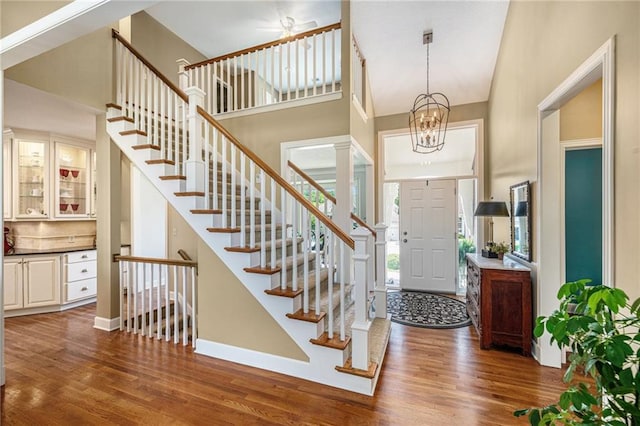 5484 NE Northgate Xing, Lees Summit, MO 64064 - entryway featuring wood finished floors, stairway, baseboards, a high ceiling, and a chandelier