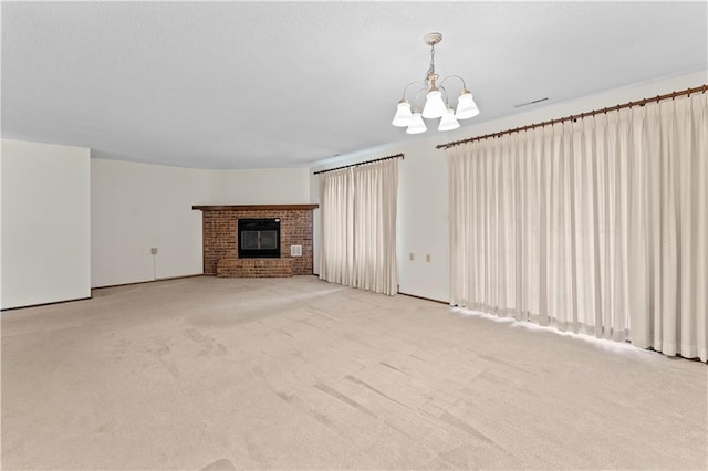 501 N Stone Blvd, Raymore, MO 64083 - unfurnished living room with an inviting chandelier, carpet, a brick fireplace, and visible vents
