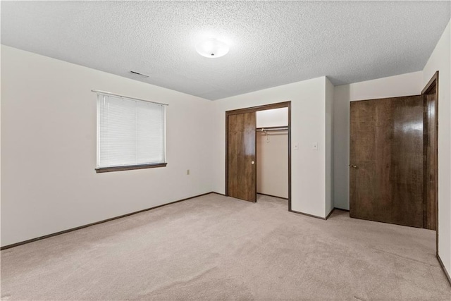 501 N Stone Blvd, Raymore, MO 64083 - unfurnished bedroom featuring a textured ceiling, light carpet, and a closet