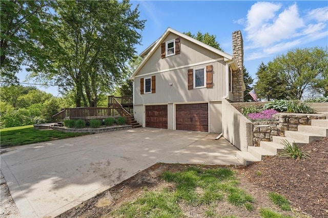 5700 N 123rd St, Kansas City, KS 66109 - view of side of home with a chimney, stairs, a garage, driveway, and a deck