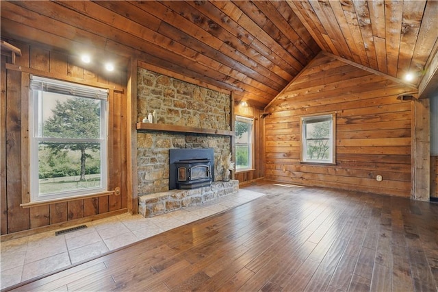 5700 N 123rd St, Kansas City, KS 66109 - unfurnished living room featuring a wood stove, wood ceiling, wooden walls, lofted ceiling, and wood-type flooring