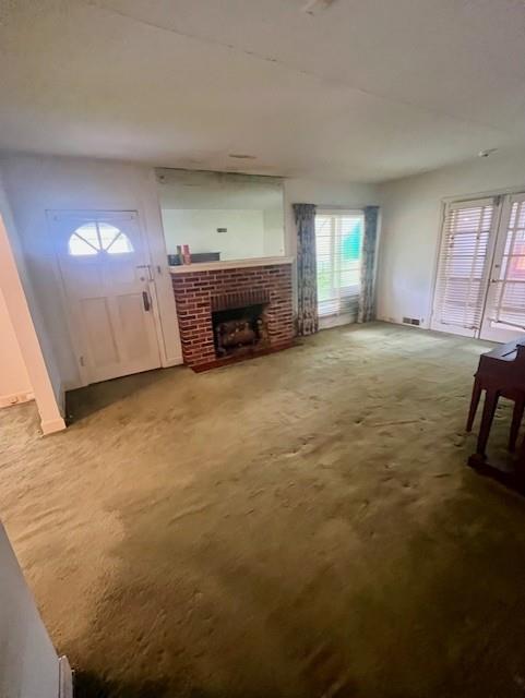 4748 Eastern Ave, Kansas City, MO 64129 - unfurnished living room featuring plenty of natural light, a fireplace, and carpet floors