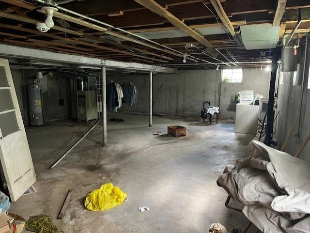 4748 Eastern Ave, Kansas City, MO 64129 - below grade area with water heater, heating unit, and washing machine and dryer