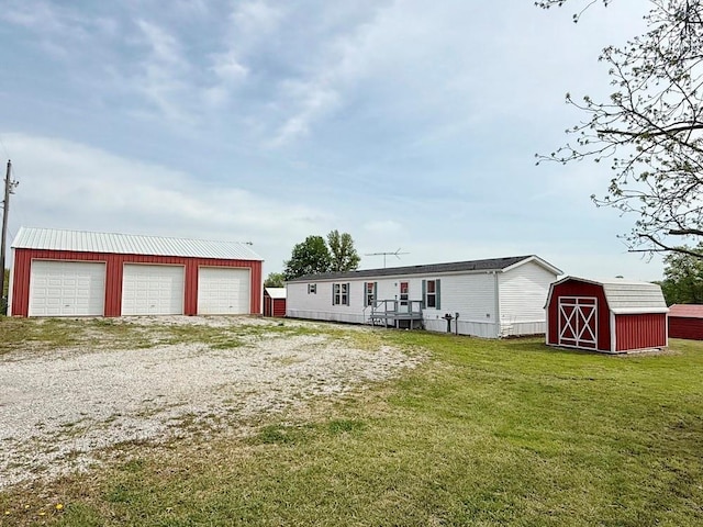 manufactured / mobile home with an outdoor structure, a front yard, a storage shed, and a garage