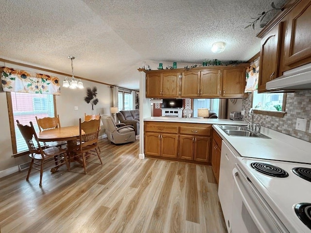 kitchen featuring brown cabinets, decorative backsplash, light wood-type flooring, light countertops, and electric range