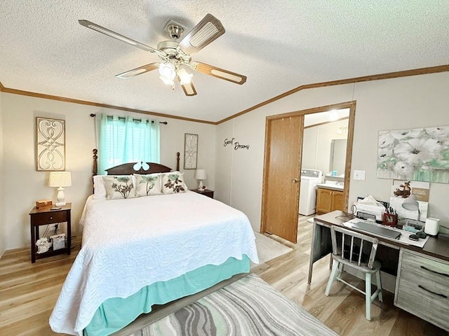 bedroom featuring lofted ceiling, a textured ceiling, crown molding, light wood-style flooring, and washer / clothes dryer