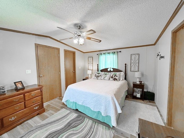 bedroom featuring vaulted ceiling, ceiling fan, light wood finished floors, a textured ceiling, and crown molding