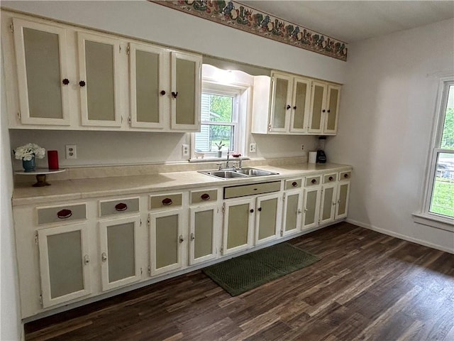 kitchen featuring a wealth of natural light, light countertops, dark wood-type flooring, and a sink