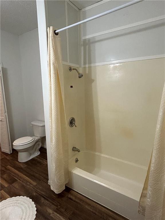 bathroom with shower / tub combo, wood finished floors, and toilet