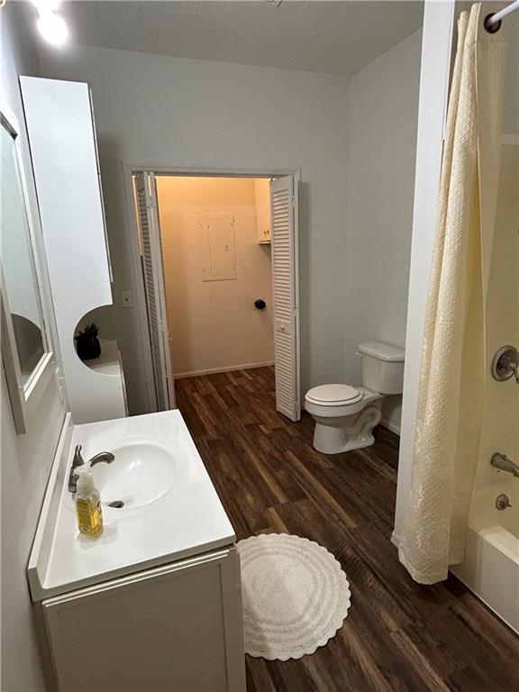 bathroom featuring shower / tub combo, wood finished floors, toilet, and vanity