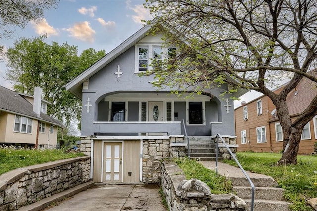 back of property featuring stucco siding and a porch
