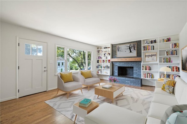 living room with a healthy amount of sunlight, baseboards, a fireplace, and wood finished floors