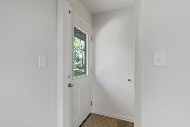 doorway to outside featuring baseboards