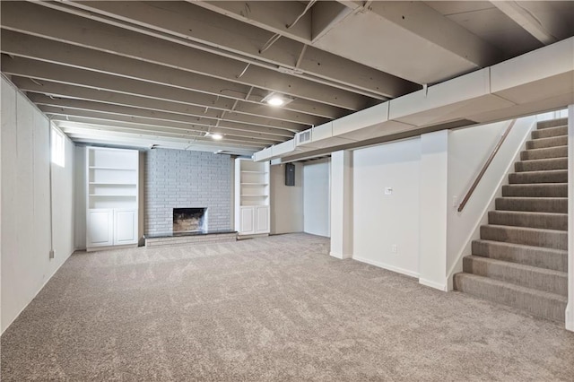 finished basement featuring a fireplace, carpet flooring, stairs, and visible vents