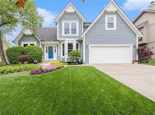 traditional home with concrete driveway, a front yard, a garage, and roof with shingles