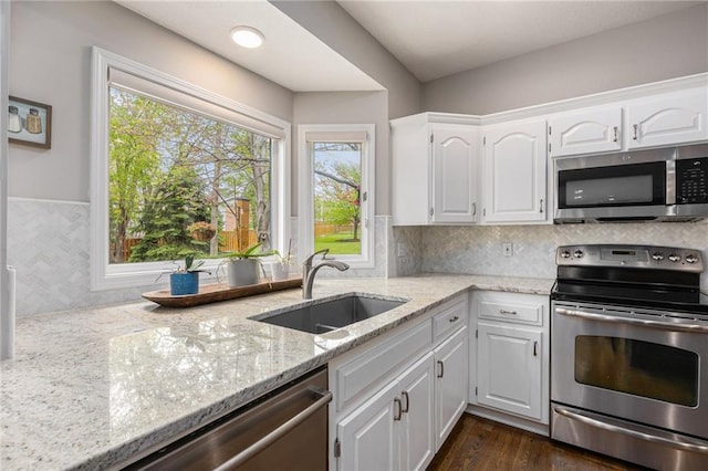 kitchen with appliances with stainless steel finishes, a sink, and white cabinets