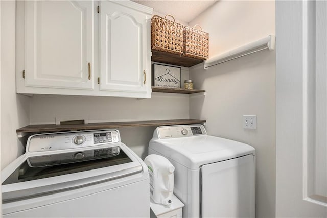 washroom featuring independent washer and dryer and cabinet space