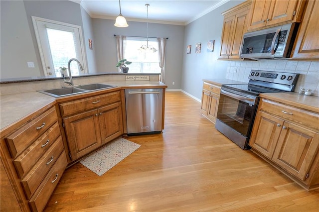 812 SW Stablewood Cir, Lees Summit, MO 64081 - kitchen with appliances with stainless steel finishes, light wood finished floors, tasteful backsplash, ornamental molding, and pendant lighting