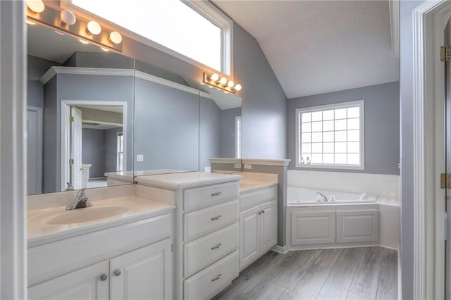 812 SW Stablewood Cir, Lees Summit, MO 64081 - bathroom with lofted ceiling, vanity, a garden tub, and wood finished floors