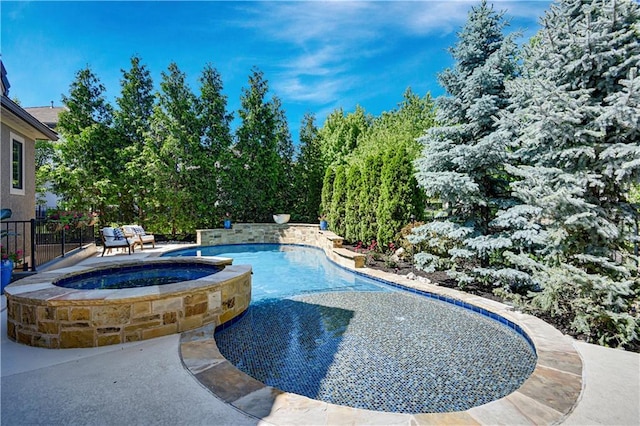 view of swimming pool with fence, a pool with connected hot tub, and a patio