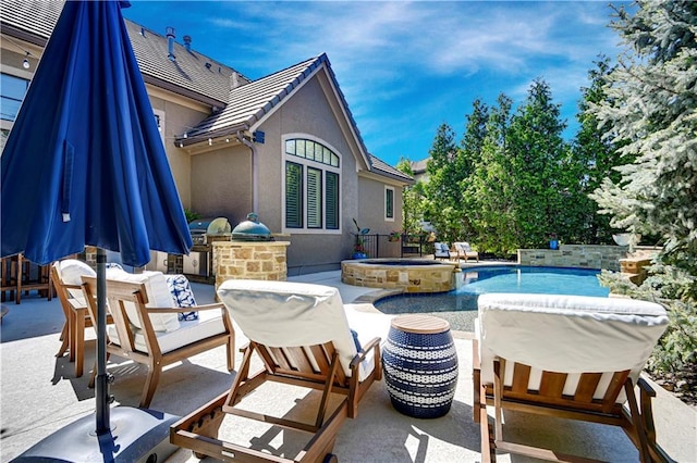 view of patio / terrace featuring an outdoor kitchen, a pool with connected hot tub, and fence