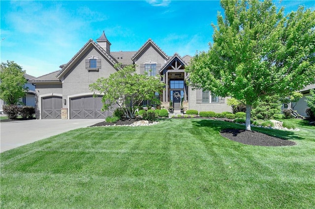 view of front of home with stucco siding, a front lawn, concrete driveway, and an attached garage