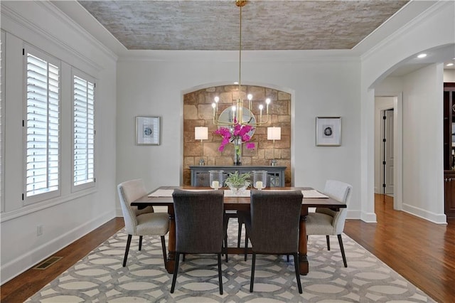 16305 Flint St, Overland Park, KS 66221 - dining area featuring wood finished floors, arched walkways, plenty of natural light, a chandelier, and ornamental molding