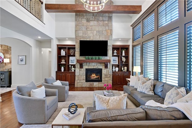 16305 Flint St, Overland Park, KS 66221 - living room with a high ceiling, wood finished floors, a fireplace, arched walkways, and beamed ceiling