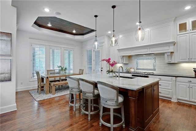 16305 Flint St, Overland Park, KS 66221 - kitchen featuring baseboards, tasteful backsplash, dark wood-style floors, a tray ceiling, and white cabinetry